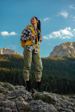Woman hiking in mountains embracing nature and adventure