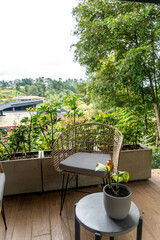 Obraz premium Balcony seating area with wicker chair and potted plants