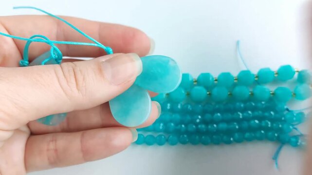 Detailed inspection and precise sizing of polished turquoise amazonite gemstone pendants and matching beaded strands utilizing accurate digital measuring tools