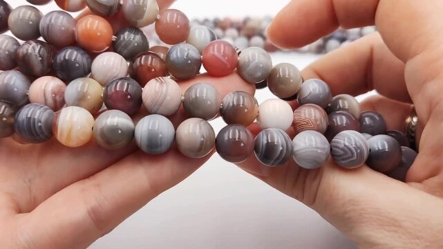 Stunning collection of polished natural striped agate gemstone round beads featuring intricate banded patterns in earthy gray brown and orange tones ideal for custom artisan jewelry making supplies