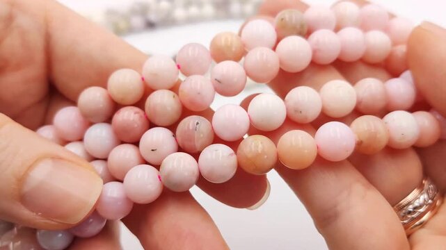 Natural pink opal gemstone round beads displayed on parallel threading strands, featuring smooth polished surfaces and gentle color variations ideal for custom artisan jewelry making components