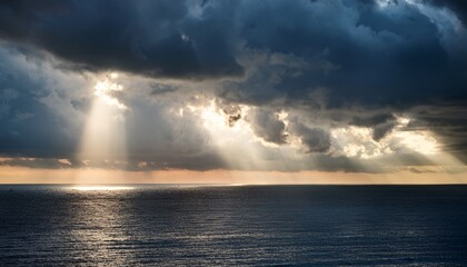 Fototapeta premium Sun Rays Breaking Through Dark Storm Clouds Over The Ocean Dramatic Weather