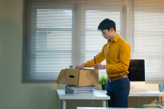 Businessman Packing Cardboard Box at Office Desk After Resignation or Job Termination