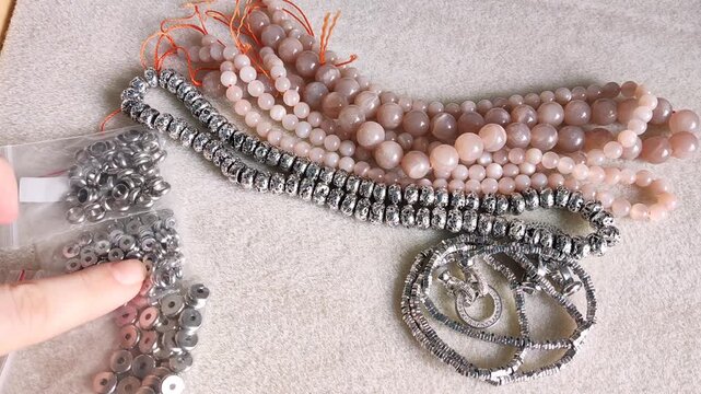 Detailed overview of premium jewelry making components showcasing polished metallic clasps, sparkling rhinestone rings, and smooth natural gemstone beads arranged for artisan design projects.
