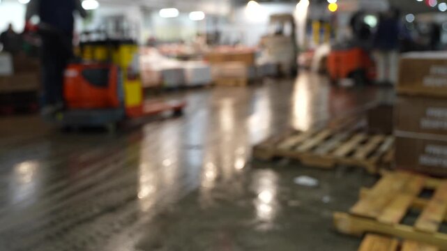 Stock footage of a worker walking through a busy industrial warehouse filled with packaged goods and logistics materials, representing supply chain operations.
