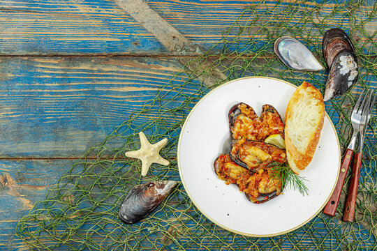 Mediterranean seafood concept. Mussels cooked in tomato salsa sauce with toasted bread, lemon, herbs