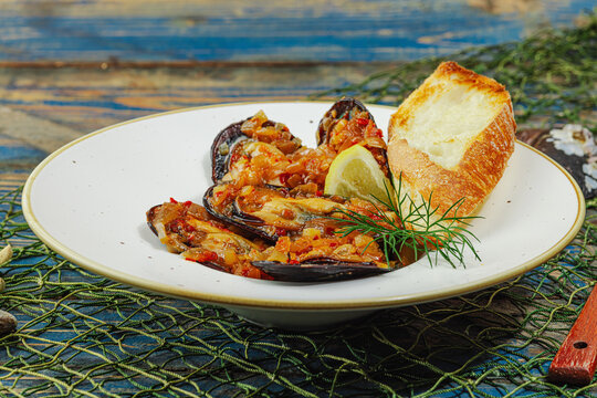 Mediterranean seafood concept. Mussels cooked in tomato salsa sauce with toasted bread, lemon, herbs