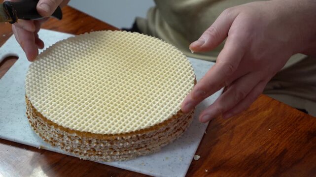 Spread wafer cakes with condensed milk. Simple cake. Sweet food. Hands closeup. Man cooking at home