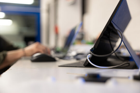 persona che lavora al computer portatile e con un tablet su una scrivania