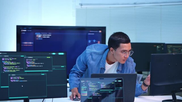 Dedicated software developer examining code on several monitors in a contemporary technology workspace