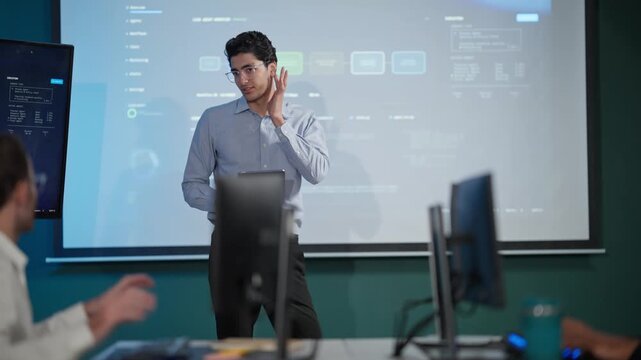 Young Businessman Presenting Data Dashboard on Screen in Modern Office
