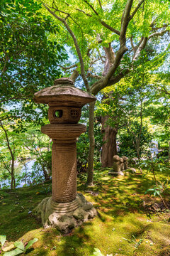 Traditional stone lantern in lush garden at Hase-dera temple in Kamakura Japan