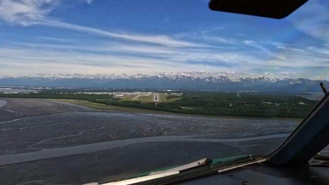Anchorage, Alaska - approach and go around from Pilots point of view (POV) at Ted Stevens Anchorage International Airport on Runway 25R, Cockpit View with mountain landscape in the background, footage