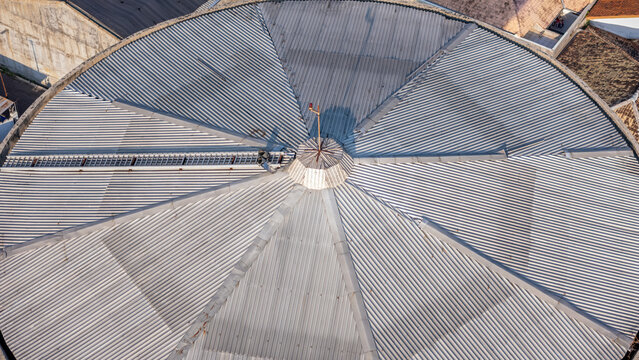 Aerial view of a circular corrugated metal roof with radial panels and a central vent in Klaten, Central Java, Indonesia.