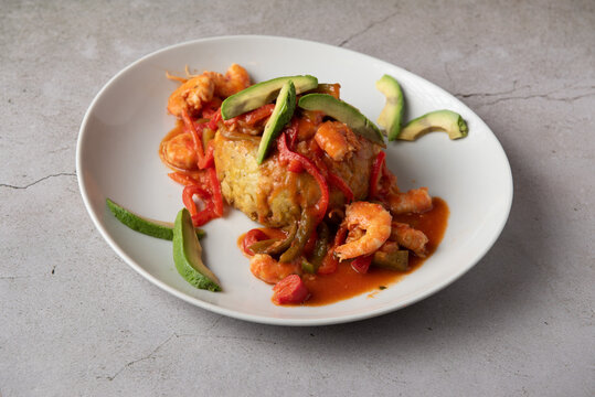Caribbean mofongo with shrimps in Creole sauce and avocado slices