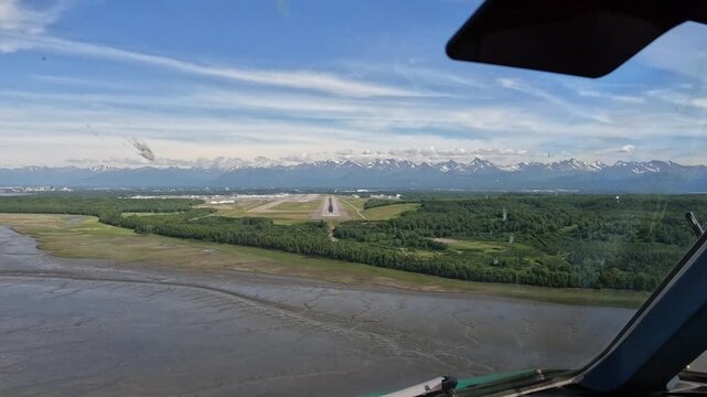 Anchorage, Alaska - approach and landing from Pilots point of view (POV) at Ted Stevens Anchorage International Airport on Runway 25R, Cockpit View with mountain landscape in the background, footage 