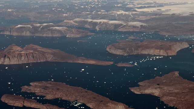 Greenland aerial landscape view, flying along Salliaruseq Island and Uummannaq Island, located in the Uummannaq Fjord, in the Avannaata municipality in northwestern Greenland  with icebergs swimming