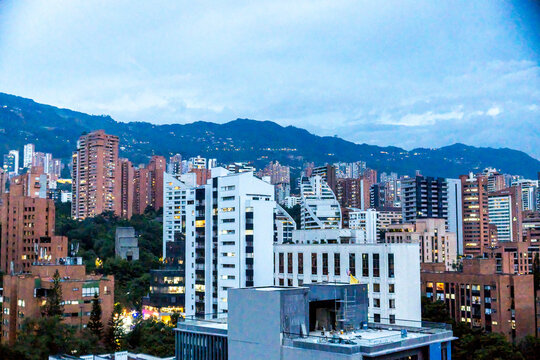 Urban city skyline with high rise buildings and hills in distance