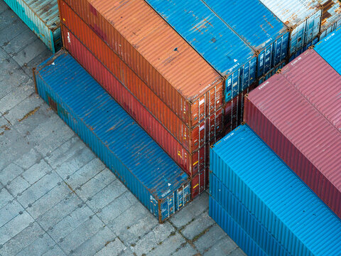 Aerial view of a cargo containers hub with stacked colorful shipping containers on a concrete surface in Poland.