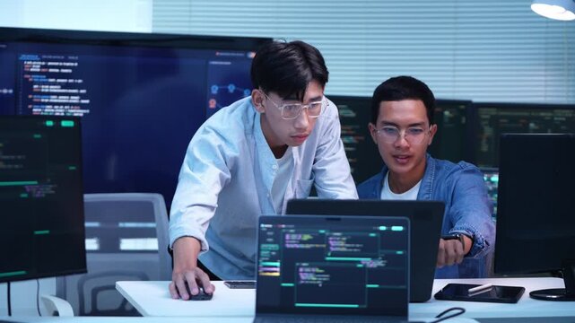 Two software developers working together on a project in a contemporary technology office setting