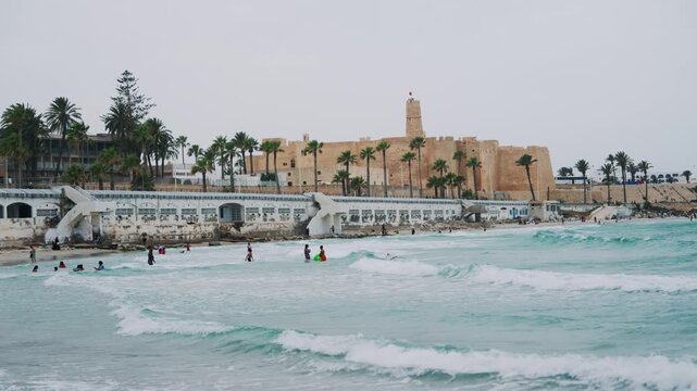 Scenic beach in Monastir, Tunisia with historic architecture and palm trees