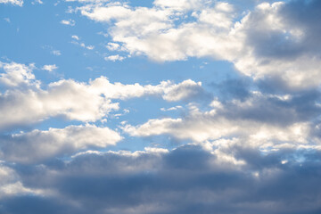 Fototapeta premium Fluffy white clouds in a bright blue sky cumulus clouds sun light