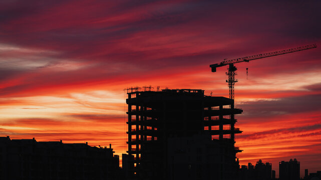 Tower crane and building under construction at sunrise, Beijing