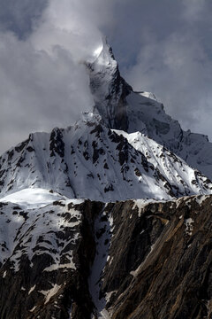 Aerial view of the dramatic granite monolith of Uli Biaho Tower rising above snow-covered peaks and rugged rock faces in Skardu, Pakistan.