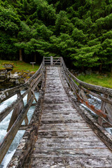 Fototapeta premium A beautiful wooden bridge over a mountain river. A seasonal scenery of Eidsdal village in World Heritage area of Western Norway.