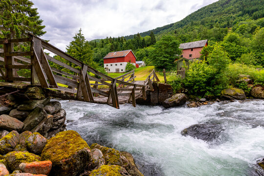 A beautiful wooden bridge over a mountain river. A seasonal scenery of Eidsdal village in World Heritage area of Western Norway.