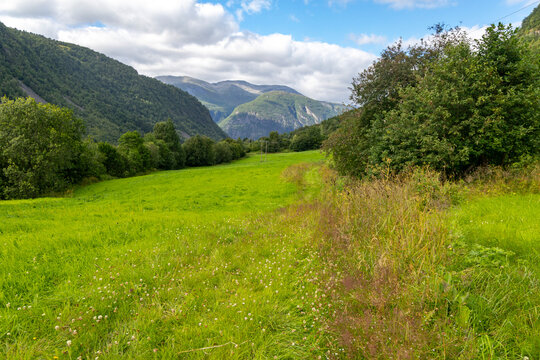 Beautiful green landscape of a hiking trail above the village. A seasonal scenery of Eidsdal village in World Heritage area of Western Norway.