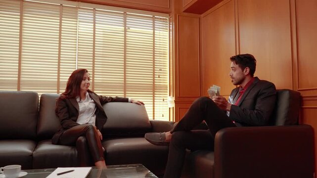 Business professionals sitting together in an office and exchanging documents while discussing a potential agreement and business decision.
