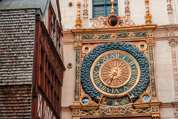Ornate astronomical clock with golden sun motif and Roman numerals mounted on historic building facade in European city, showcasing intricate architectural details © Надія Коваль