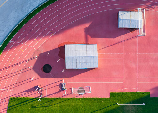 Aerial view of Sports and Recreation Center featuring a red running track and green grass field in Starogard Gdanski, Pomeranian Voivodeship, Poland.