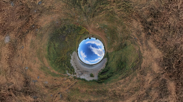 Aerial view of the 360-degree panoramic landscape of Little Gaynor Lake surrounded by grassy fields and open plains in Longmont, Colorado, United States.