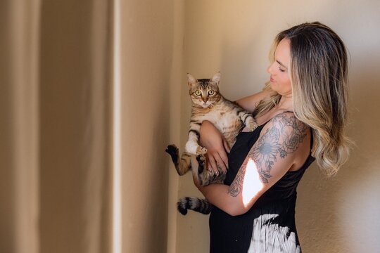 mulher com gato tigre no colo
