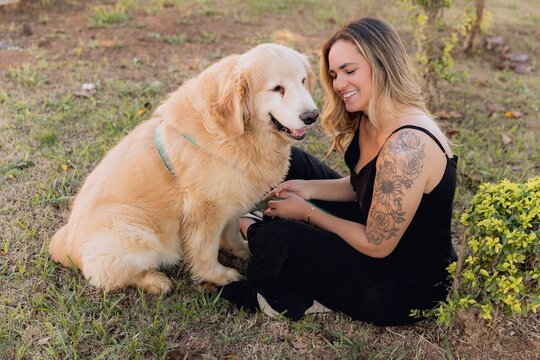 Mulher sorrindo com cachorro golden