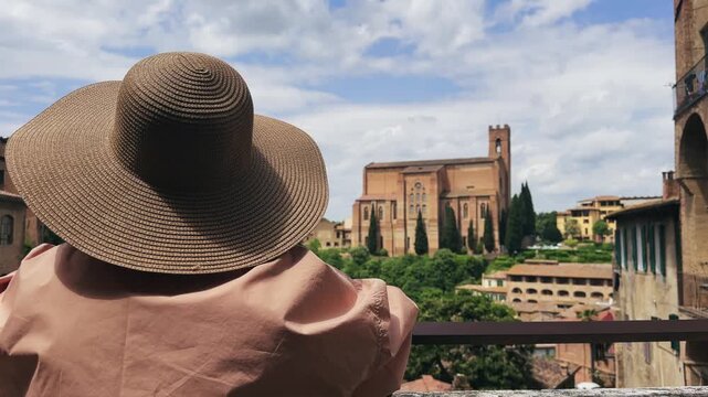 Stylish tourist woman with hat enjoy panoramic view of Siena Historic Basilica Cateriniana San Domenico in Tuscany, Italy