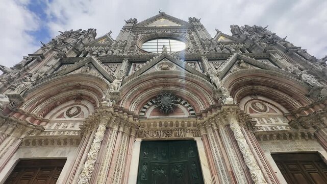 Grand entrance to Siena Duomo Cathedral in Tuscany, Italy, showcasing ornate details, intricate sculptures, and exquisite design that represents historical architectural mastery