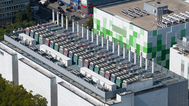 Aerial view of a data center rooftop featuring rows of industrial cooling units and ventilation pipes on a modern building in Frankfurt am Main, Hessen, Germany.