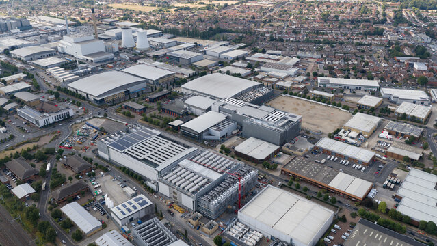 Aerial view of the industrial district featuring large warehouses, cooling towers, and commercial buildings in Slough, England, United Kingdom.