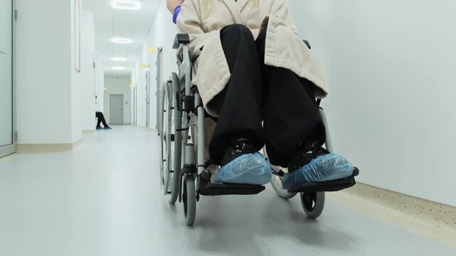 Woman wheelchair user receives assistance from female medic in clinic closeup. Healthcare accessibility for patient rehabilitation