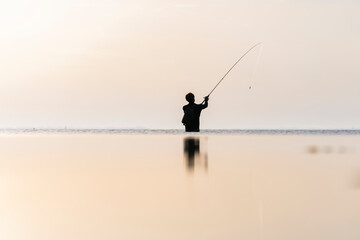 Pescador en la playa un amanecer con barco de fondo y el mar en calma © Conmisojos