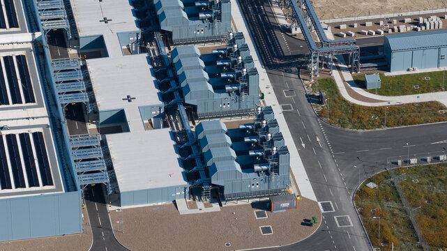 Aerial view of an industrial power plant facility featuring large machinery, complex piping systems, and paved access roads in Groningen, Groningen, Netherlands.