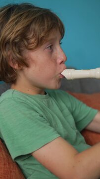 A little boy learns to play the flute at home, practicing with focus and enthusiasm in a cozy, warm setting. A charming scene of early musical exploration, creativity, and childhood growth.