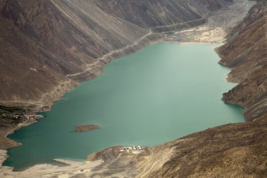 Aerial view of Satpara Lake surrounded by rugged mountains and arid terrain in Skardu, Pakistan.