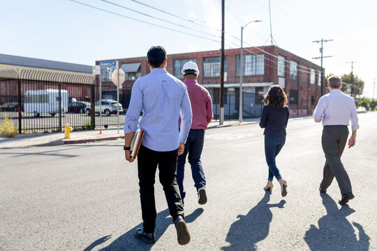 Group walking towards industrial building.