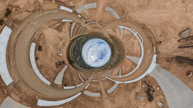 Aerial view of a construction site featuring circular dirt patterns, concrete pathways, and heavy machinery in Longmont, Colorado, United States.