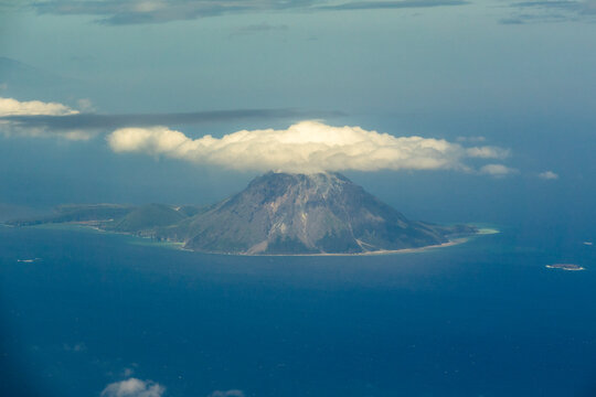 Aerial view of a volcanic peak covered by a cloud from an airplane window, Osumi islands, Satsuma Iojima, Japan