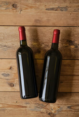 Obraz premium Wine culture and hospitality two red wine bottles on rustic wooden table for celebration dinner party winery marketing and beverage industry